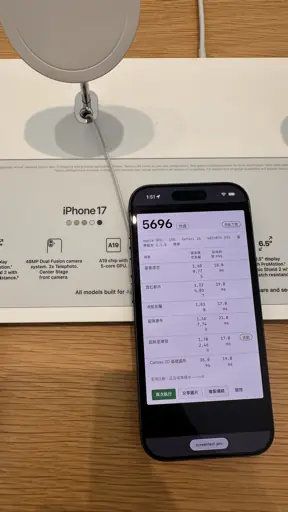 iPhone 17 in an Apple Store showing a Screen Test Pro score of 5696 under benchmark 2.1.0